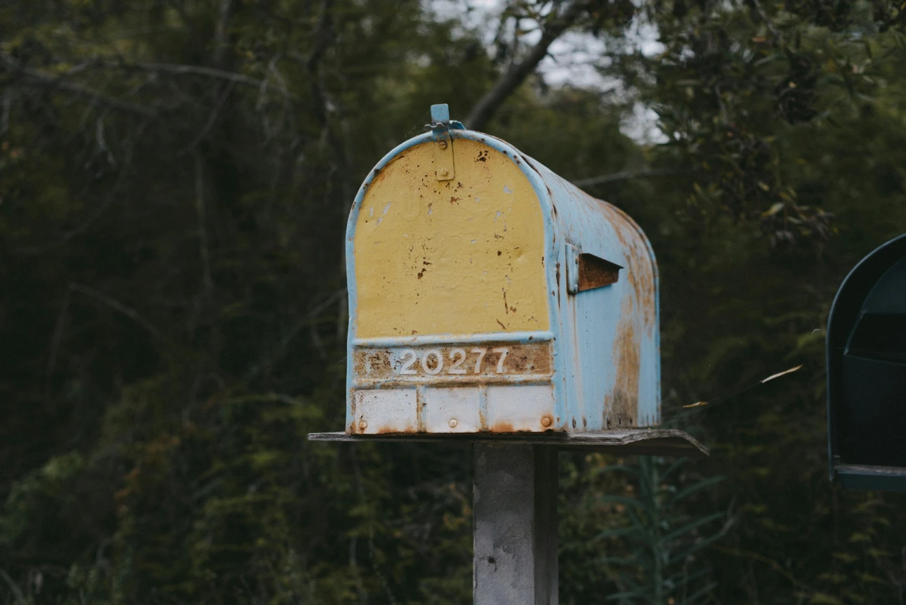 brown wooden mail box on brown wooden post